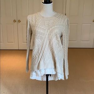 Cable knit sweater with lace hem.